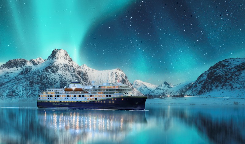 Aurora borealis over snowy mountains, frozen sea coast, reflection in water at night. Lofoten islands, Norway. Northern lights. Winter landscape with polar lights, ice in water. Starry sky with aurora