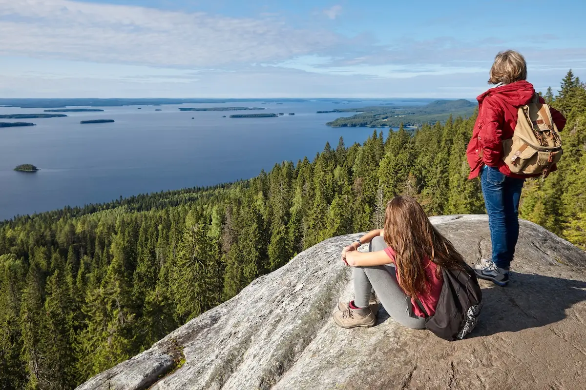 Finnish landscape at sunset with hikers. Lake Pielinien. Koli viewpoint